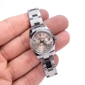 Hand holding a silver wristwatch close-up.