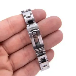 Hand holding a metal watch bracelet clasp.