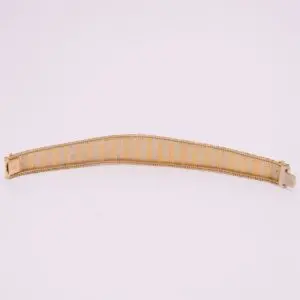 Gold mesh bracelet on white background.