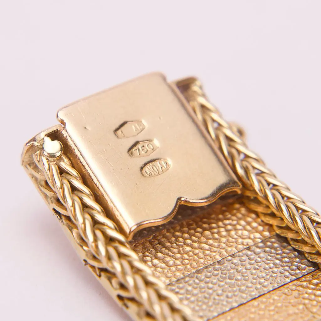 Gold bracelet clasp with hallmarks, close-up.