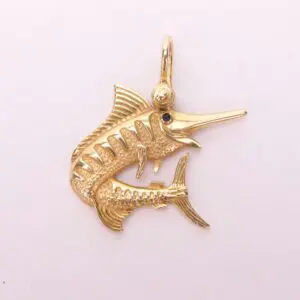 Gold marlin fish pendant with gemstone eye.