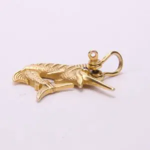 Gold marlin fish pendant on display.
