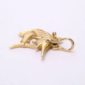 Gold marlin pendant with gemstone eyes.