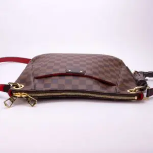 Brown checkered handbag with gold accents.