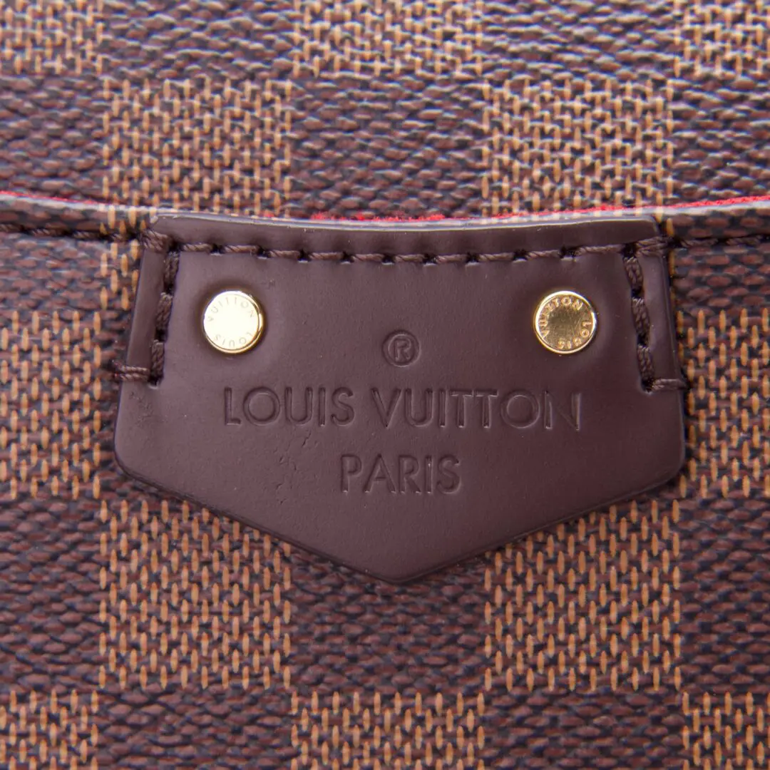 Louis Vuitton bag close-up, brown checkered pattern.