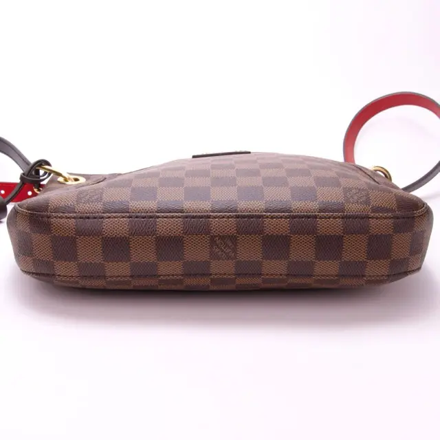 Checkered handbag with red and black straps.