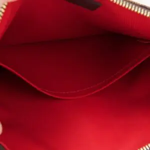 Open handbag with red interior and zipper.