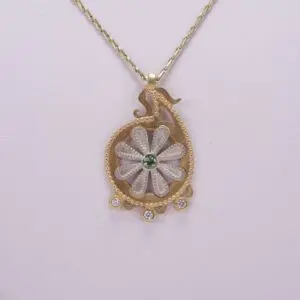 Gold necklace with floral pendant design.