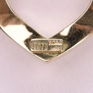 Gold heart-shaped pendant with engraved text.