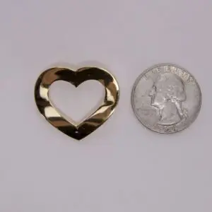 Gold heart cutout beside a quarter coin.