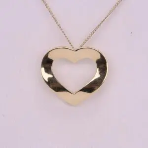 Gold heart-shaped pendant on chain necklace.