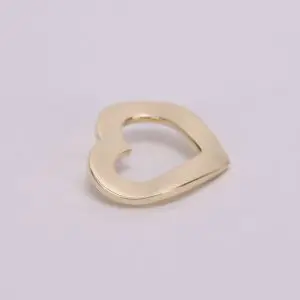 Gold heart-shaped pendant on light background.