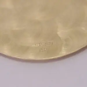 Close-up of gold surface with markings.