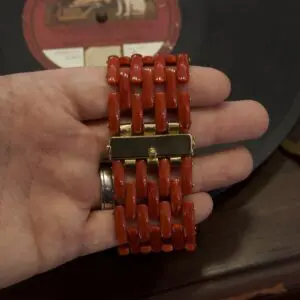 Hand holding a red beaded bracelet.