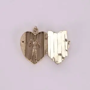 Heart-shaped locket with small figure inside.
