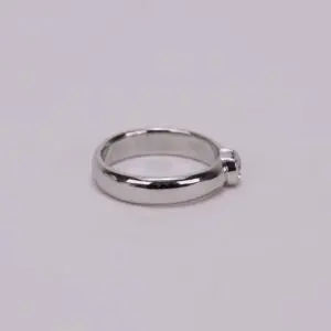 Silver ring with single round gemstone.