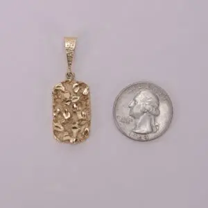 Gold pendant next to a quarter.