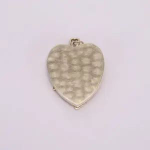 Gold heart-shaped locket on white background.
