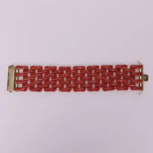 Red linked bracelet on pink background.