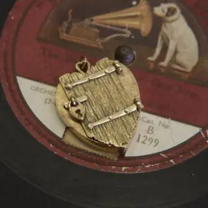 Gold pendant on vintage record label background.
