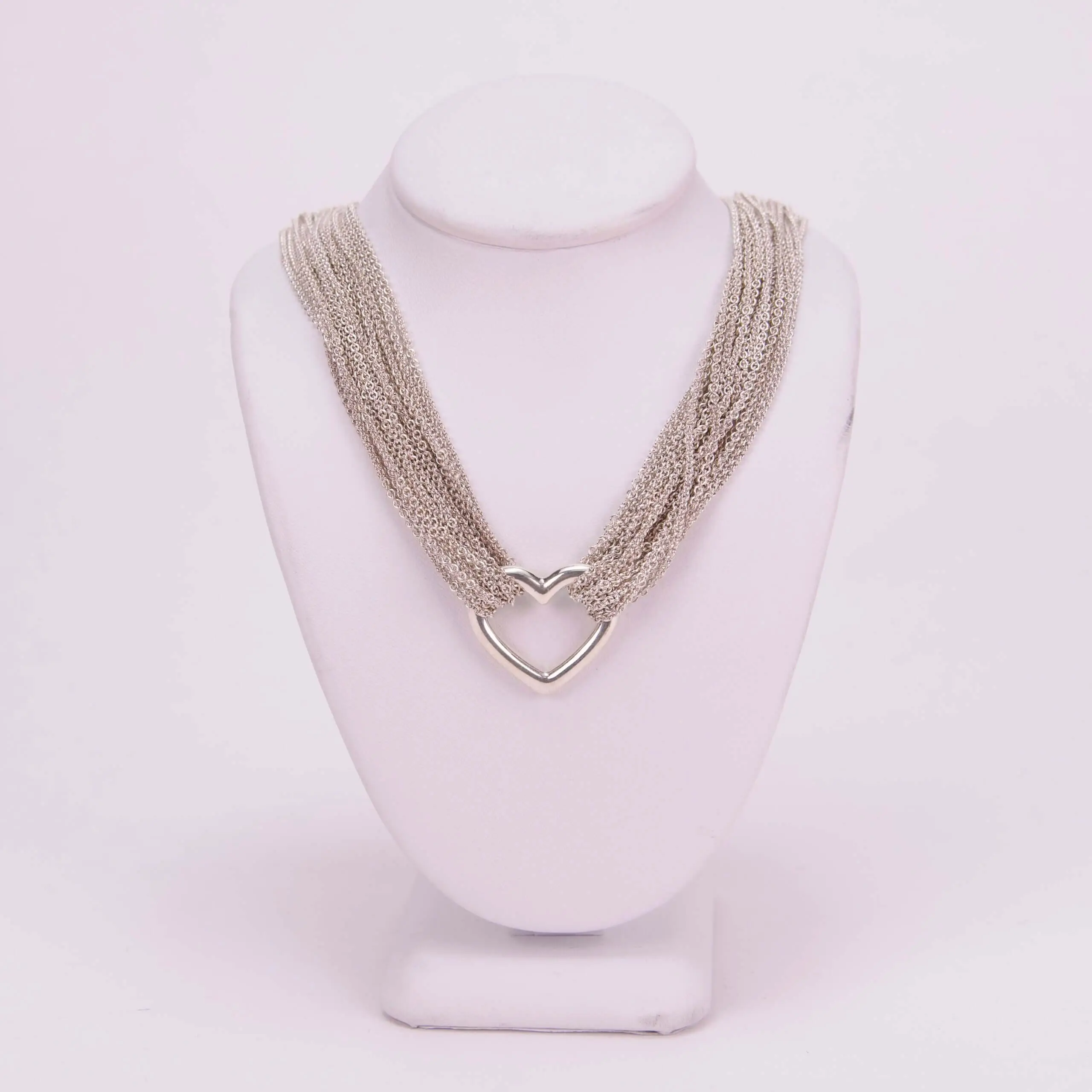 Silver heart chain necklace on display stand.