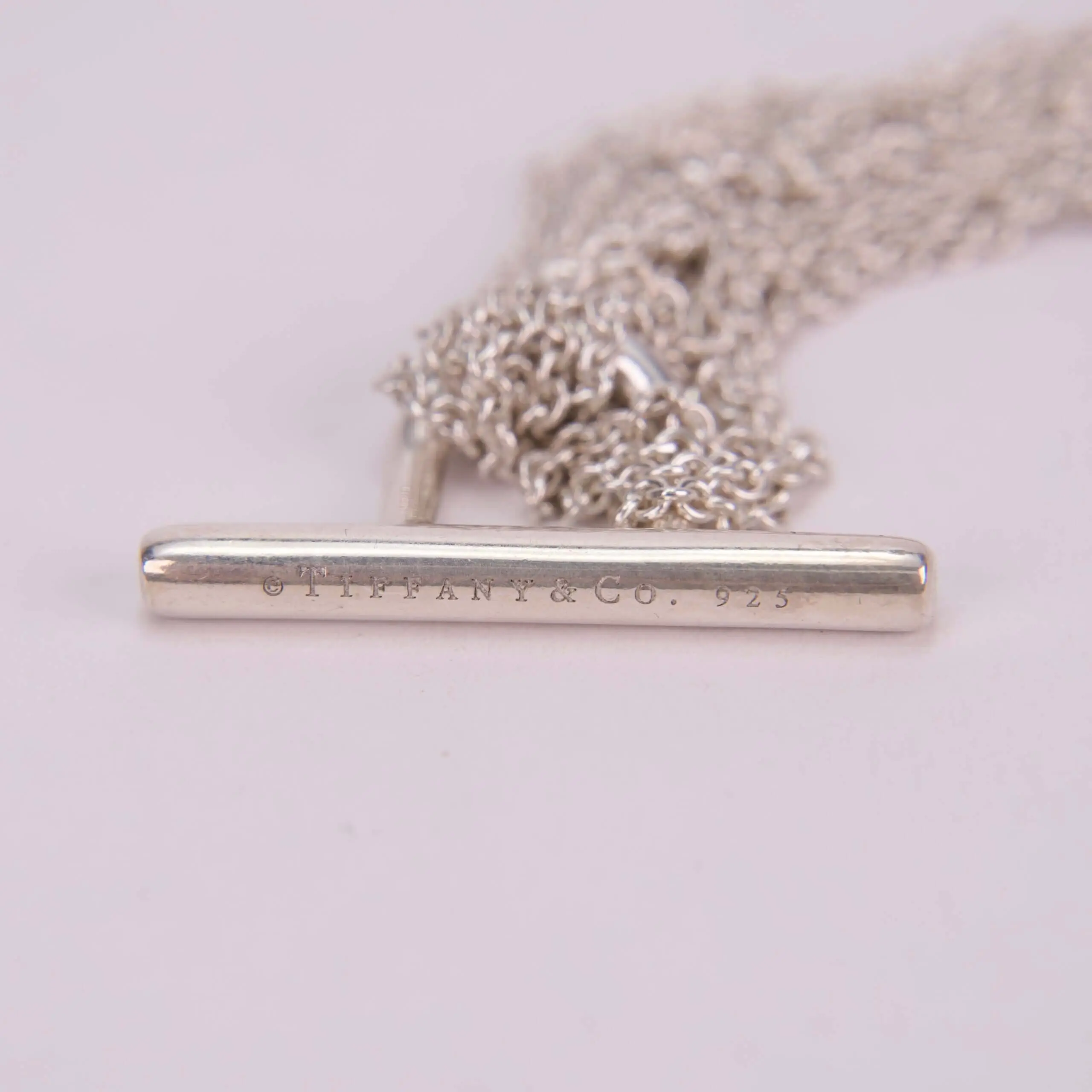 Silver chain with engraved bar clasp.
