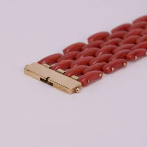 Red bracelet with gold clasp detail.