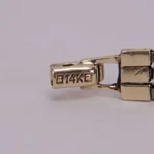 Gold clasp with "914KC" engraving detail.