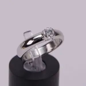Silver ring with a round diamond setting.