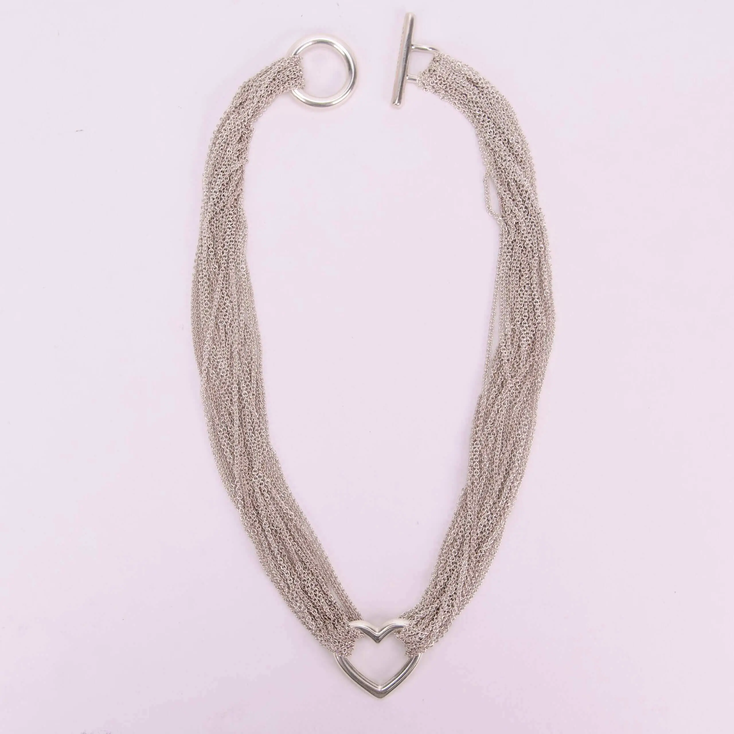 Silver necklace with heart-shaped pendant.