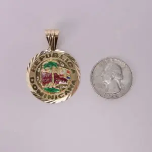 Gold Dominican Republic pendant beside quarter.