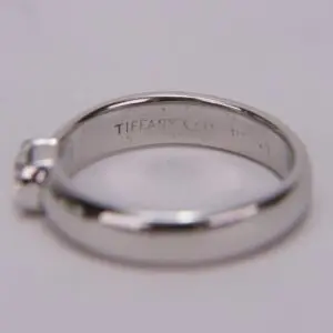 Silver ring with engraved brand name inside.