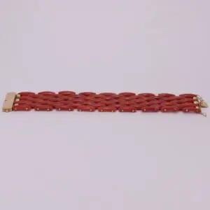 Red link bracelet with gold clasp.