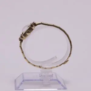 Gold watch on a transparent display stand.