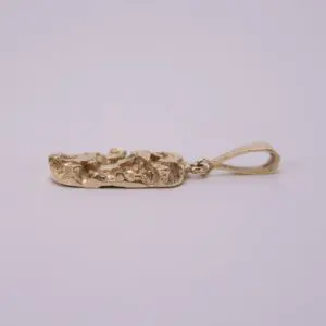 Gold pendant with textured design, side view.