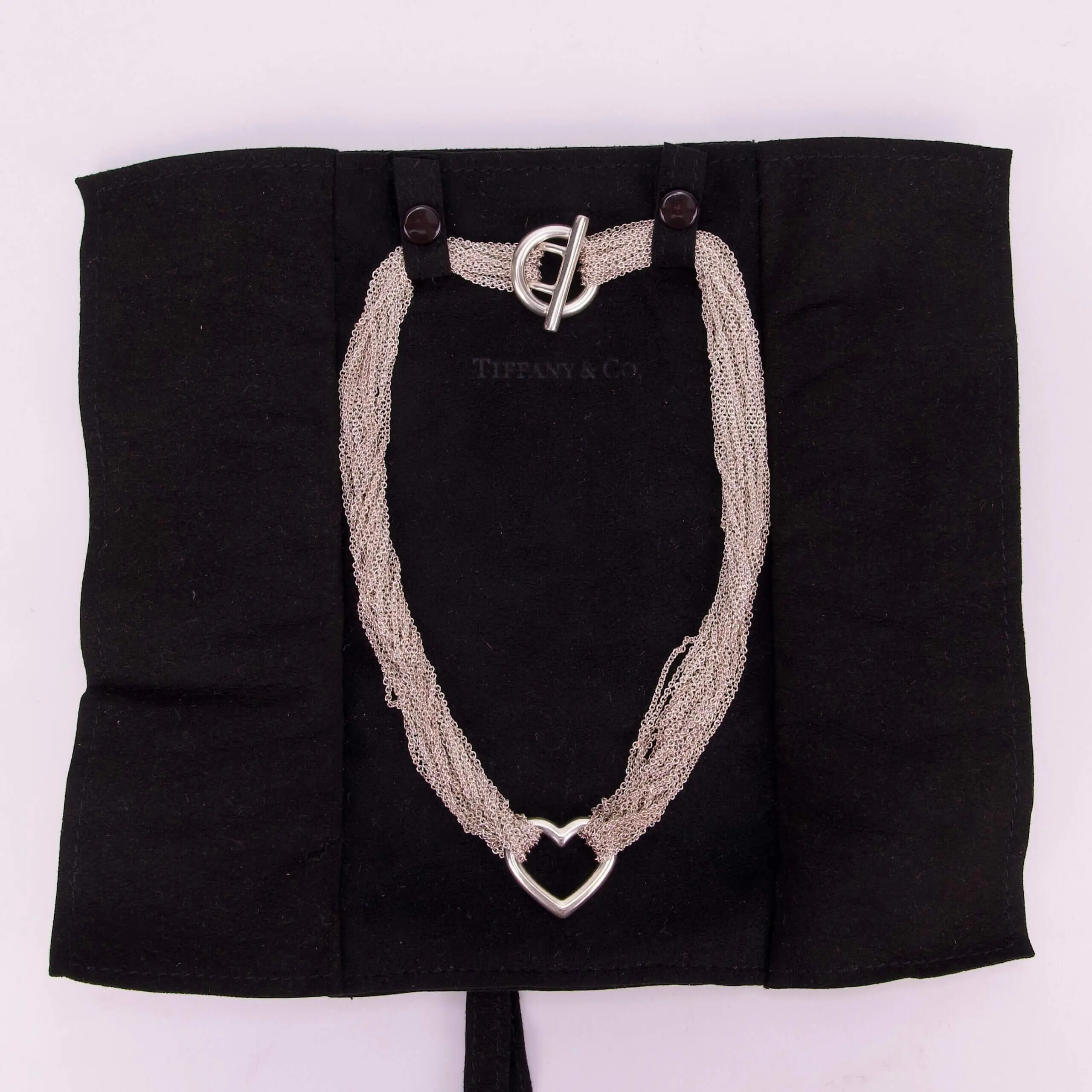 Heart-shaped necklace on black fabric display.