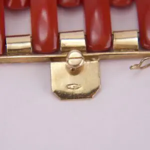 Gold clasp with red beads detail.