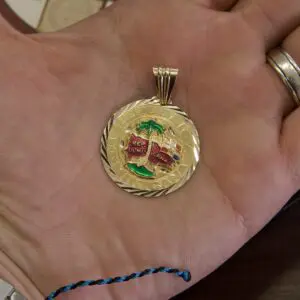 Gold pendant with Dominican emblem in hand.