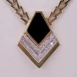 Gold and diamond pendant with black center.