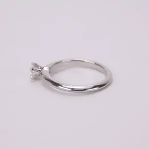 Silver ring with single diamond on band.