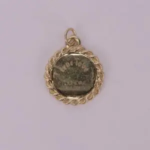 Gold medallion with engraved text.