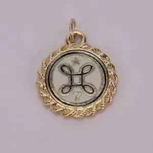 Gold pendant with star and decorative symbol.