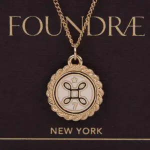 Gold pendant necklace with decorative emblem.