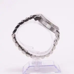 Silver wristwatch on a clear stand.