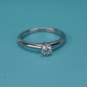 Diamond ring on turquoise background.
