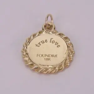 Gold pendant with "true love" engraving.