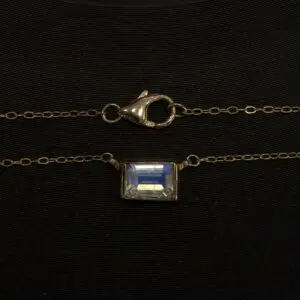 Gold chain with clasp and gemstone pendant.