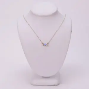Gold necklace with a square gemstone pendant.