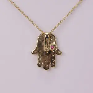 Gold Hamsa necklace with pink gem.