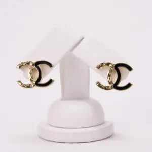 Gold and black designer logo earrings.